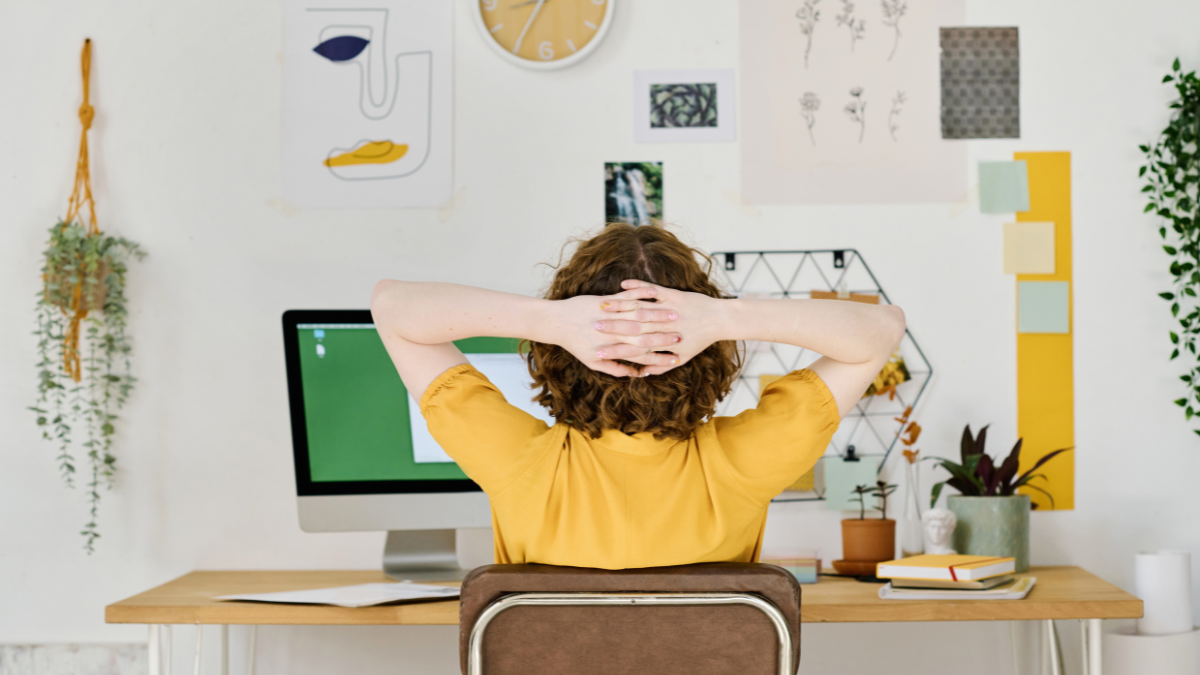 Rear view of young freelance designer having minute of rest while sitting in front of computer monitor and keeping hands behind head best freelance jobs.