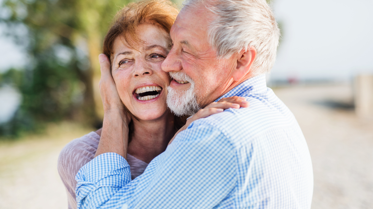 Close-up of senior couple on a holiday on a walk, hugging.