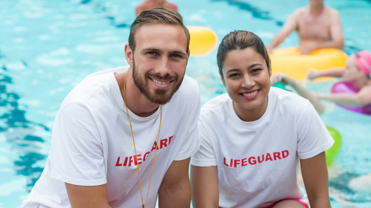Portrait of male and female lifeguards crouching at poolside Good Jobs for Teenagers.