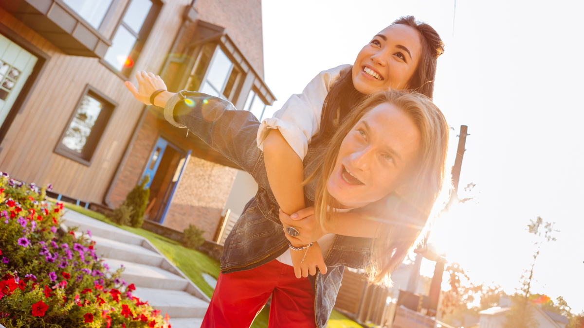 New life. Happy positive couple standing in front of their house while being just married Real Estate Stocks.