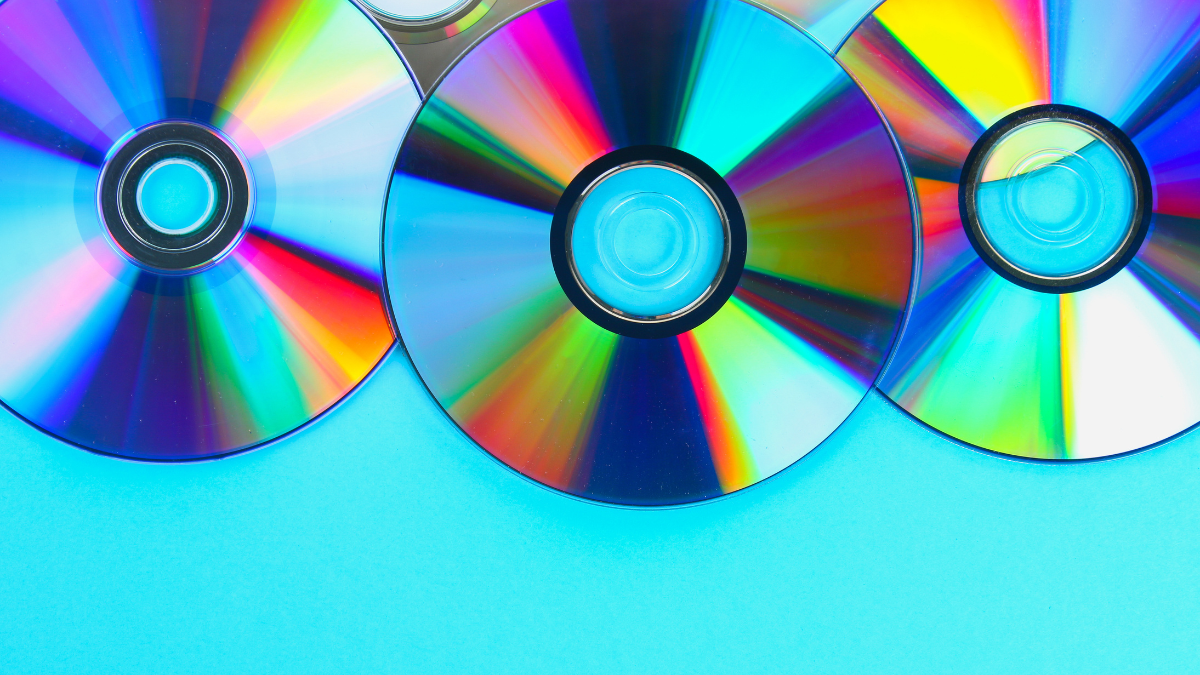 Piles of old and dirty CDs,DVD on pastel background. Used and dusty disk with copy space for add text. Sell Used DVDs.