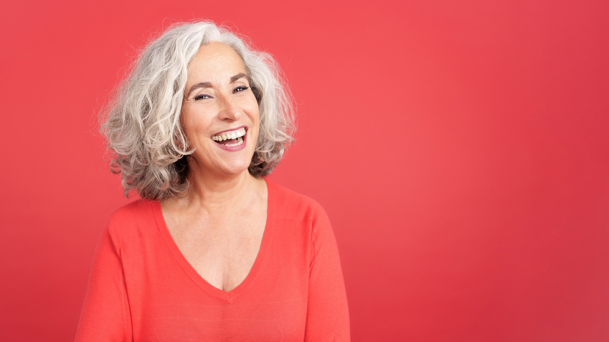 Mature woman laughing standing with arms crossed best jobs for retirees.