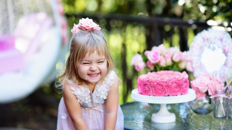 Little girl celebrate Happy Birthday Party with rose decor in the beautiful garden.