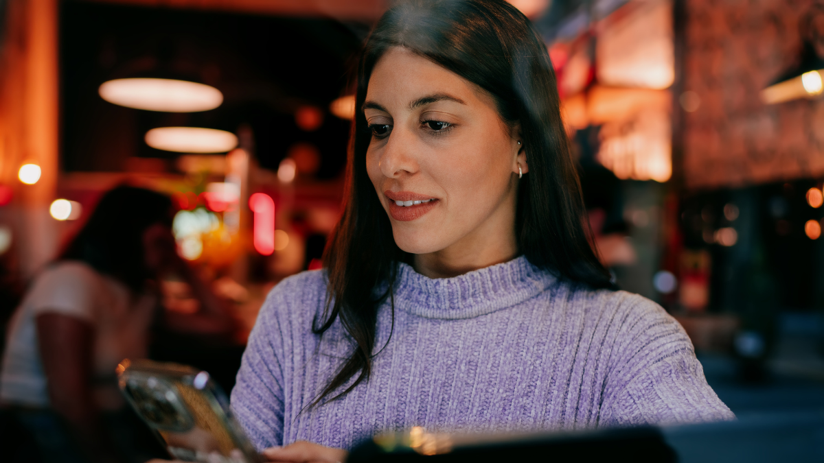 Close up of smiling brunette woman looking at tablet screen. Digital banking, mobile payment, online shopping or social media interaction. Tech savvy user enjoying high speed internet connection.