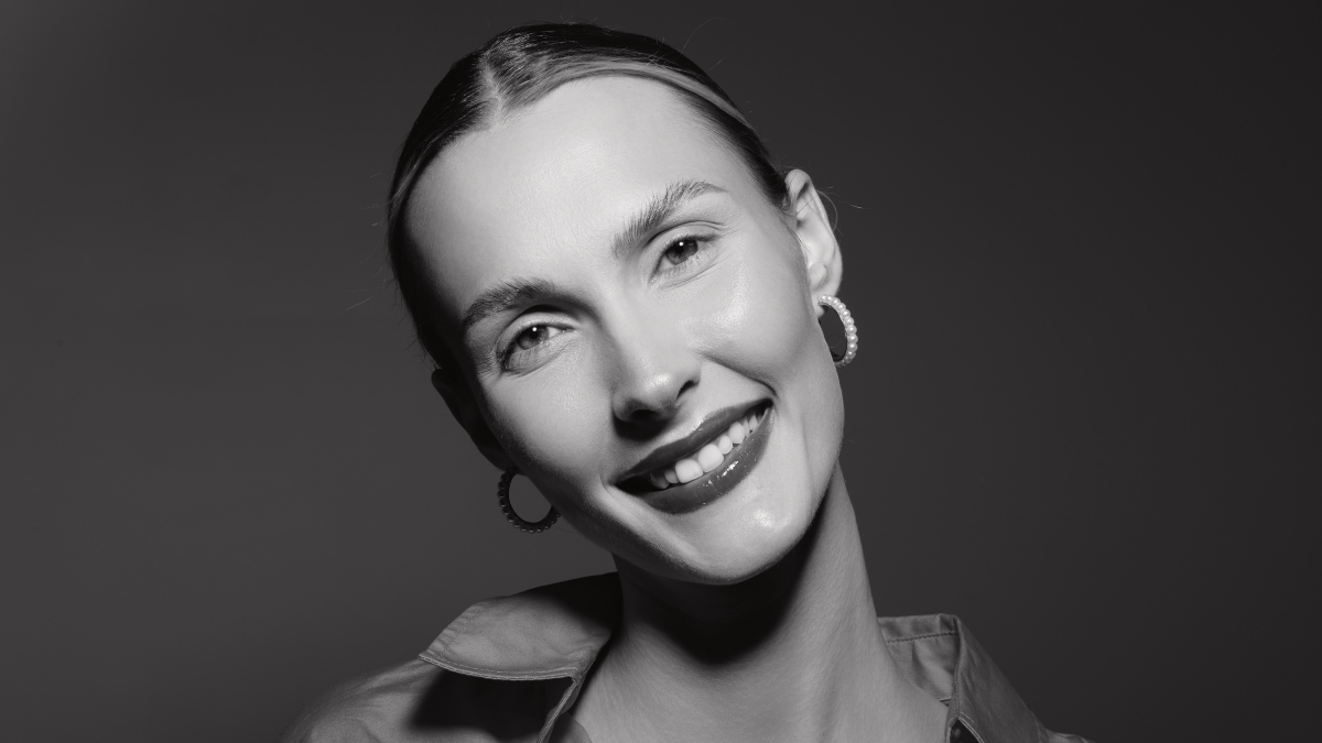 Smiling white woman with pale skin and earrings poses in studio wearing an open collar shirt. Concept of beauty, happiness, fashion, and female portrait. Legit Ways To Make Extra Cash.