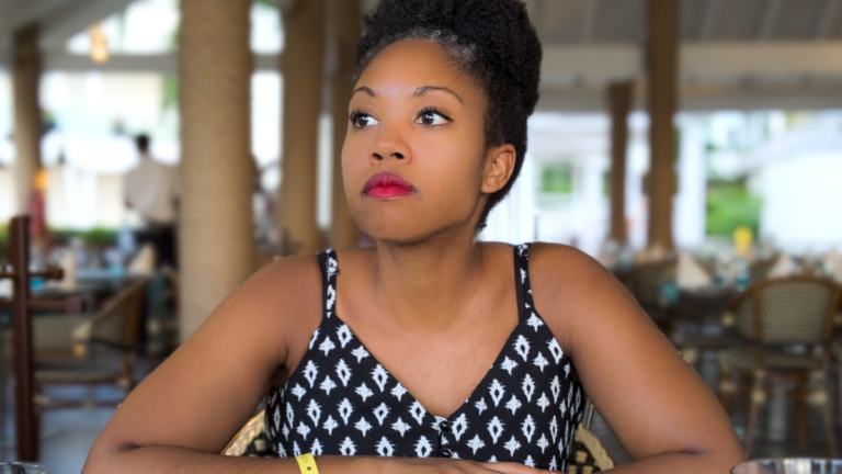 woman wearing tank top sitting at table