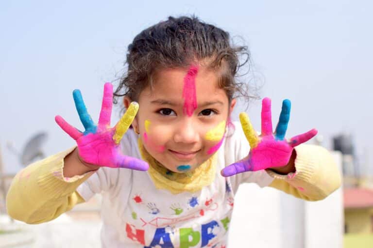 happy child with paint on hands and face