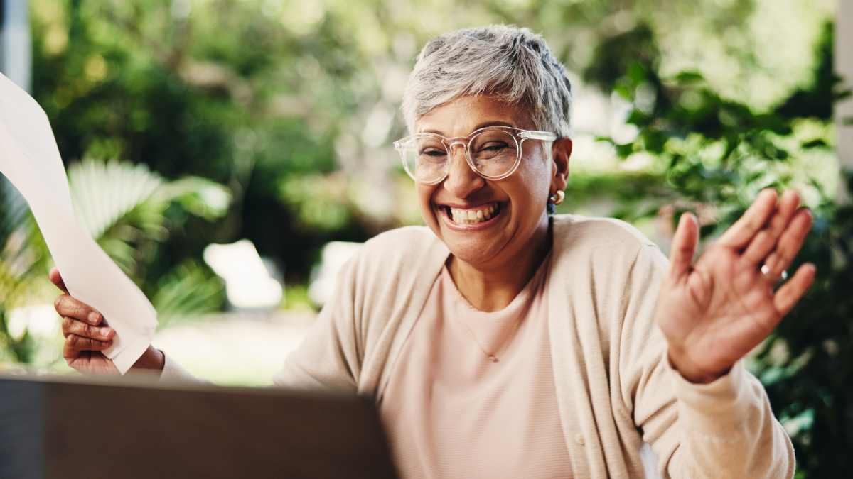 Senior, happy woman or winning with laptop or receipts for tax return, deduction or finance at home. Mature, female person and celebration with smile for financial freedom, retirement or pension fund how to get free money.