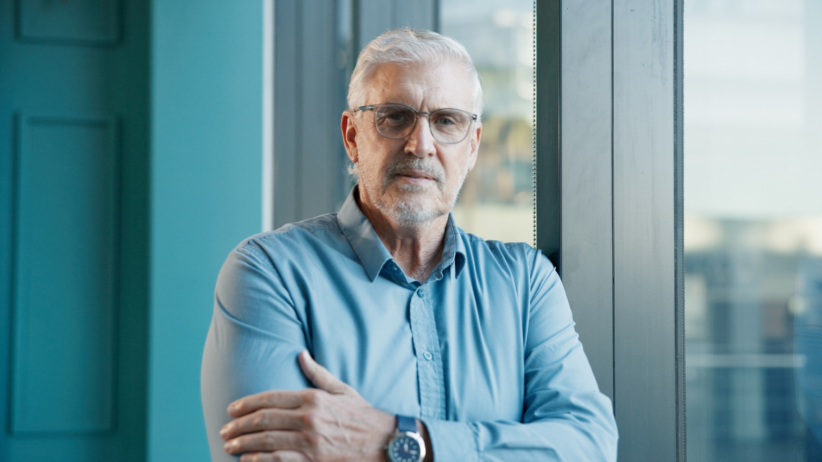 Portrait, arms crossed and glasses with business man in office for trader, pride and stock broker. Investment banker, financial advisor and wealth management with mature person in finance firm options trading.