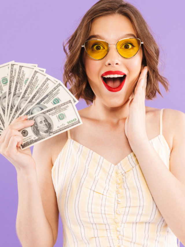 excited woman holding sheaf of bills
