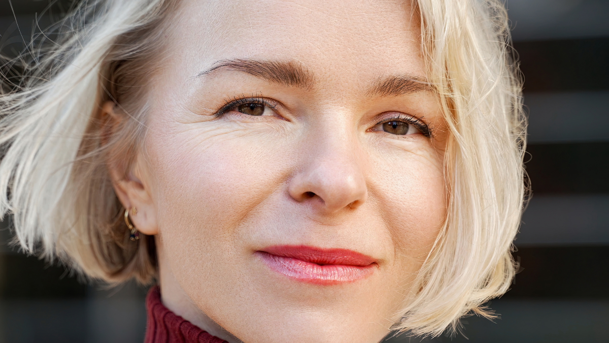 Close-up portrait of a beautiful middle-aged blond woman with short hair and brown eyes.