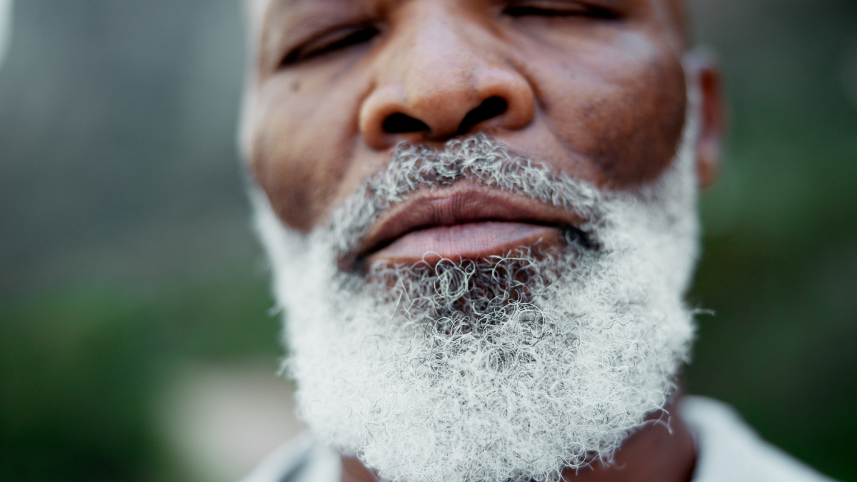 Senior, black man and outdoor with eyes closed for peace on mountain, mindfulness and breathing for fresh air. Elderly person, closeup and calm in environment for sustainability, serenity and nature.