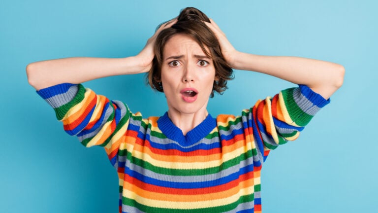 Portrait of nice worried brown-haired girl bad news reaction isolated over bright blue color background.