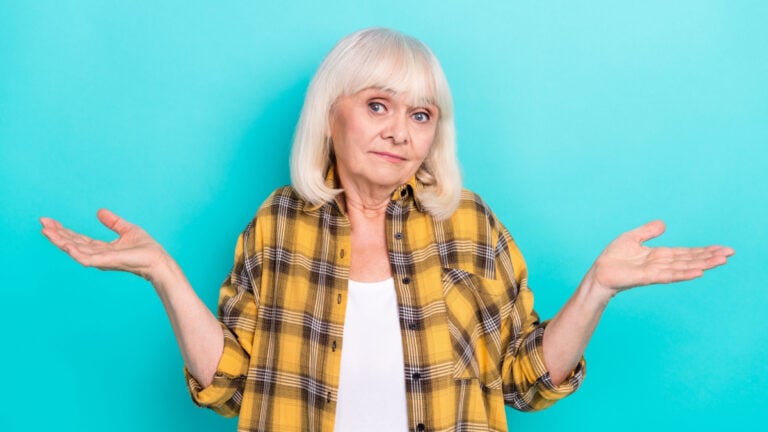 Photo of pretty sad upset mature woman shrug shoulders puzzled thoughtful isolated over teal color background.