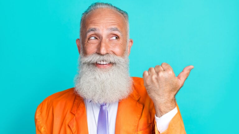 Portrait of positive aged man toothy smile look direct thumb finger empty space blank isolated on emerald color background.