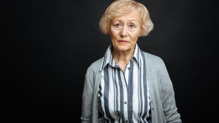Pitiful aging woman demonstrating comparison indoors.