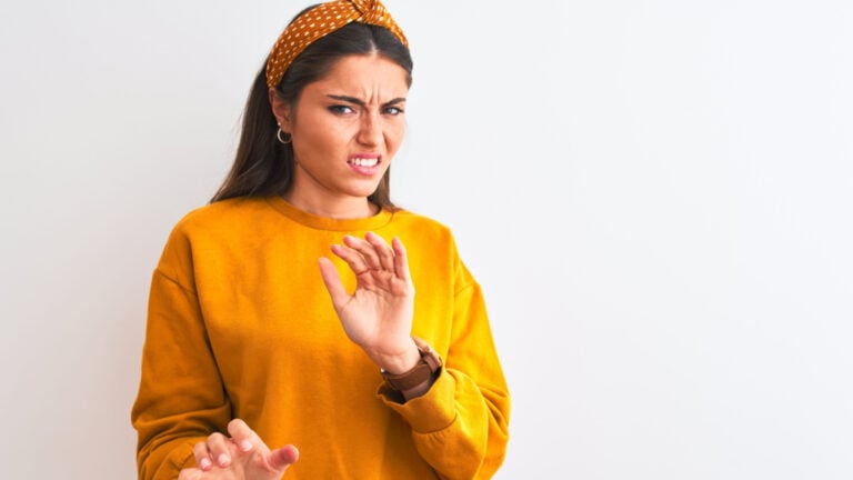 Young beautiful woman wearing yellow sweater and diadem over isolated white background disgusted expression.