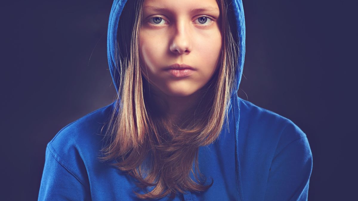 Sad teen girl in hood.