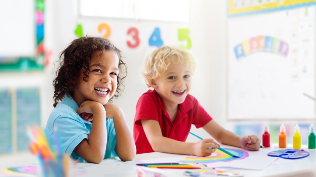 Kids go back to school. Interracial group of children of mixed age in classroom.