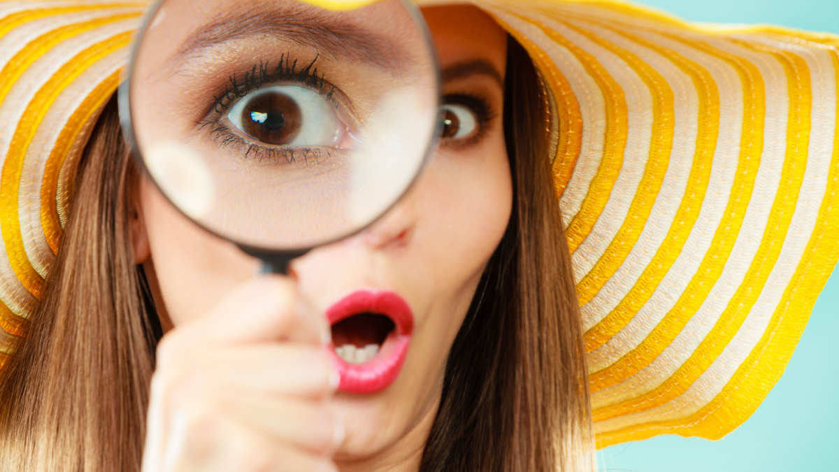 Investigation exploration education concept. Closeup woman face surprised expression, girl holding on eye magnifying glass loupe.