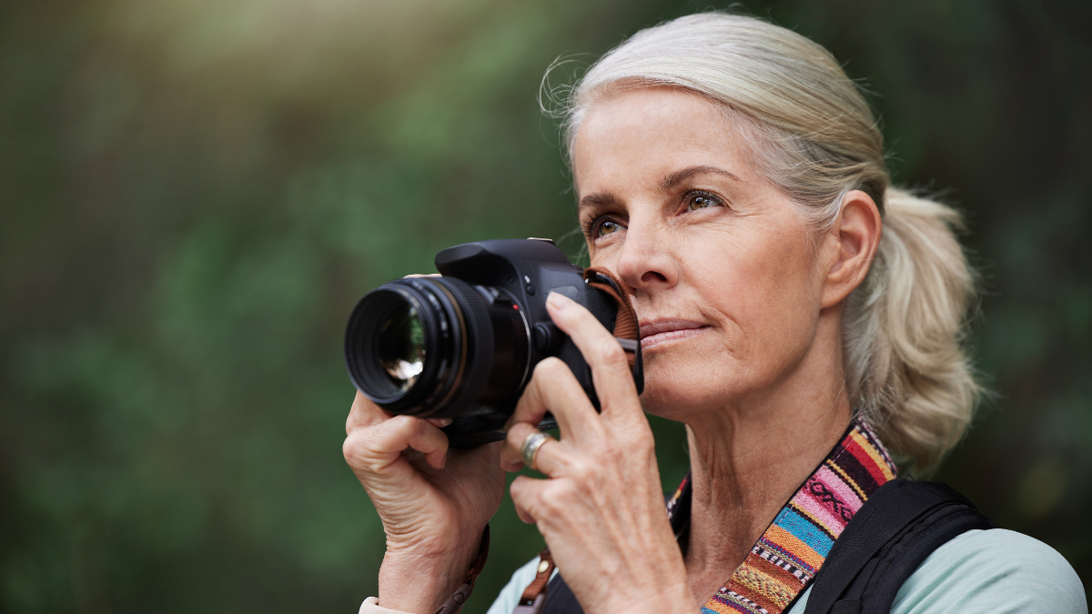 Nature, hiking and mature woman taking pictures, fitness and memories with wellness, healthy lifestyle and wireless device. Senior female tourist, lady and photographer with camera, hike and walking.