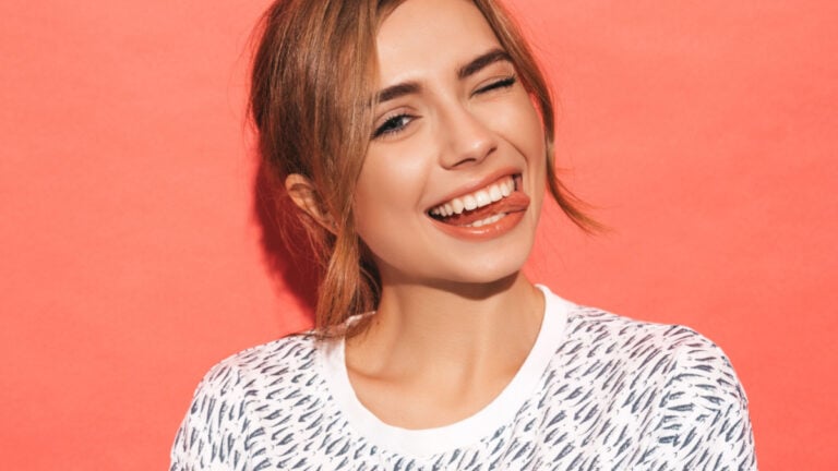 Young beautiful woman looking at camera. Trendy girl in casual summer shirt clothes with natural makeup. Positive female smiling.