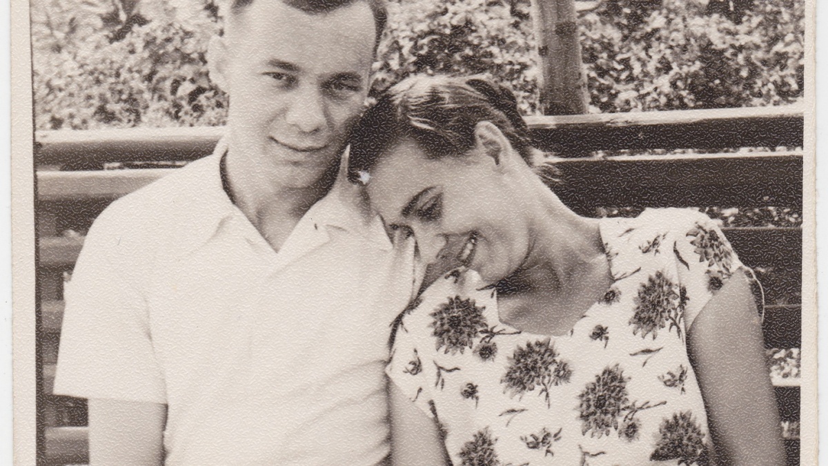 Vintage photo of handsome young people huddled together, sitting on a bench in a summer garden.