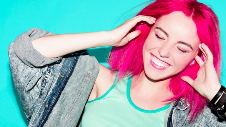 Laughing Teenager girl with pink hair Stylish hair color trend.