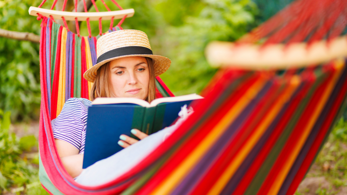 Young woman reading book while lying in comfortable hammock at green garden almost effortless ways to save money.