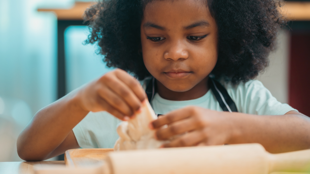 Close up of little girls having a playful while making or preparing ingredients, dinner or lunch for the whole family, home online cooking class, wellbeing activity at home, carefree hobby in family.