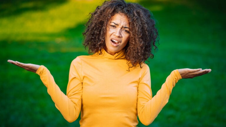 woman saying shrugs her arms, makes gesture of I don't know, care, can't help anything .