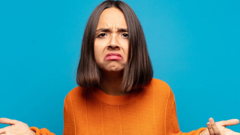 hispanic woman feeling clueless and confused, having no idea, absolutely puzzled with a dumb or foolish look.