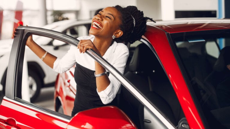 Woman buying the car. Lady in a car salon. Elegant black girl.