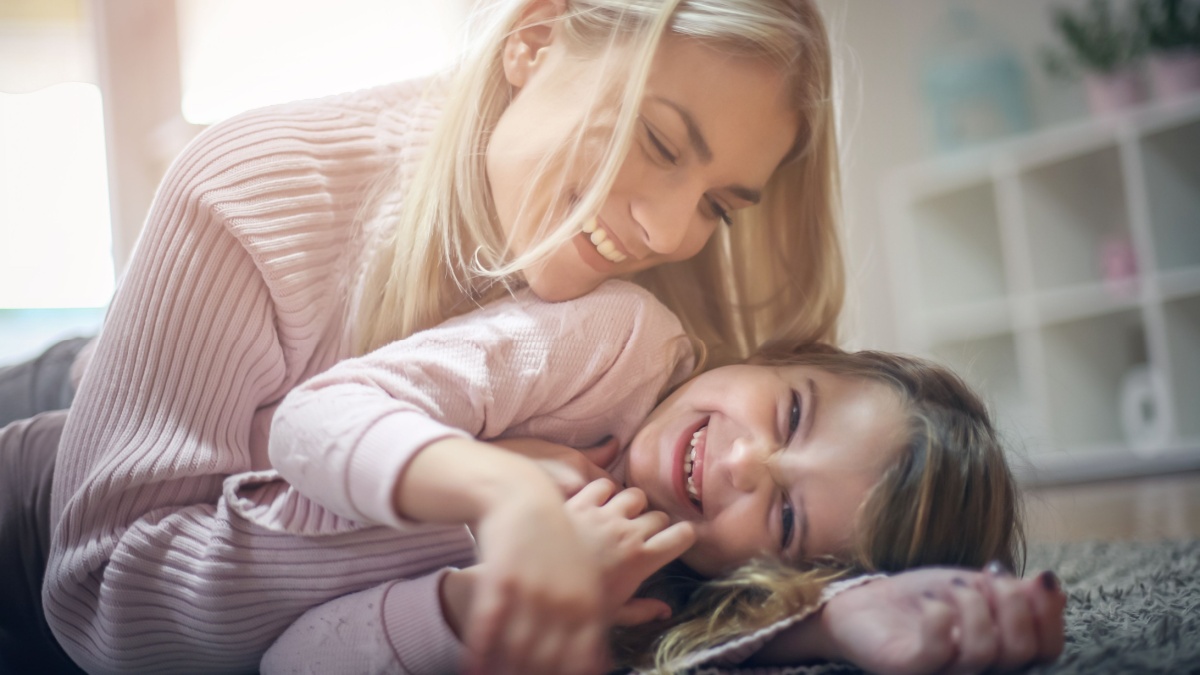 Mother and daughter having fun at home. Close up.