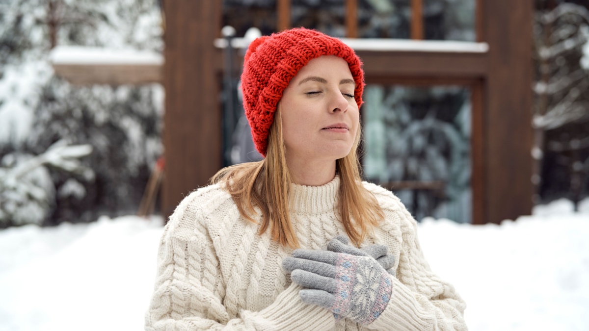 Adult caucasian woman breathing fresh air in winter time.