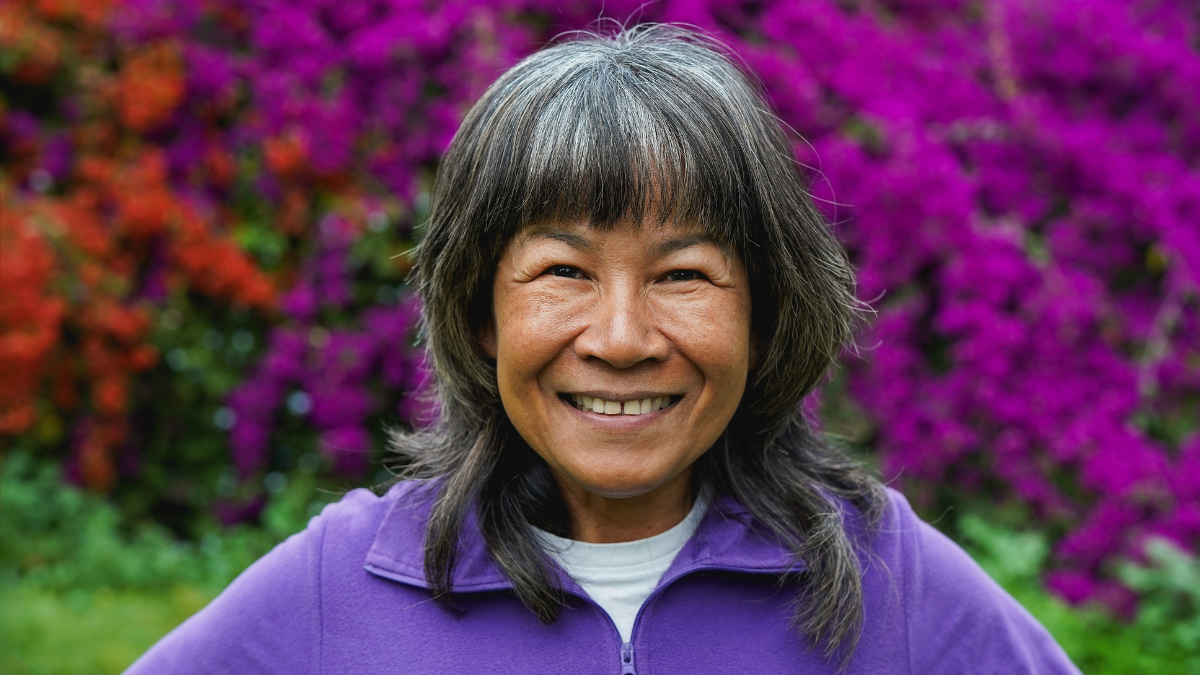 Happy mature asian woman smiling on camera at city park after yoga class - Joyful elderly person, lifestyle and sport concept.