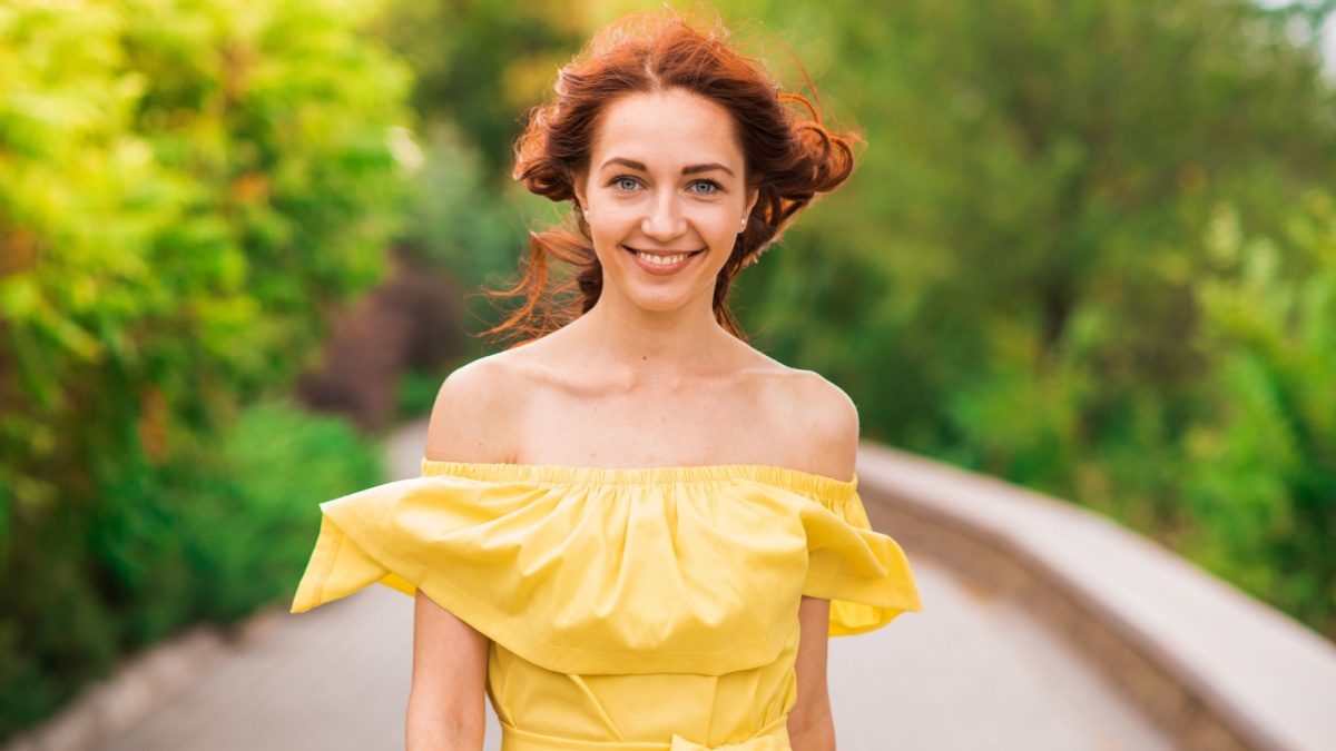 Happy beautiful redhead girl walking in the park.