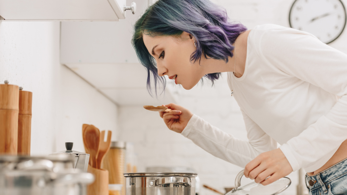 Selective focus of girl with colorful hair preparing food .
