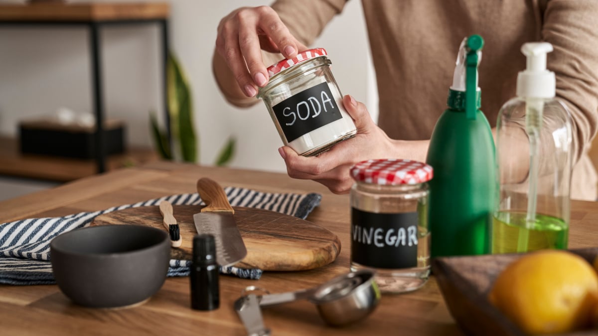 Unrecognizable person making cleaning product from ecological ingredients.
