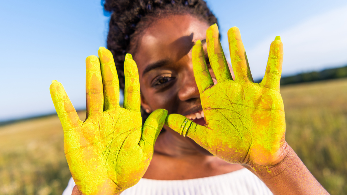Girl with yellow paint on palms.
