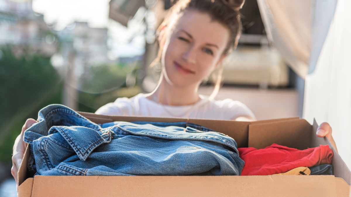 Cardboard box with clothes inside. Concept donation and reuse or recycle your used clothes