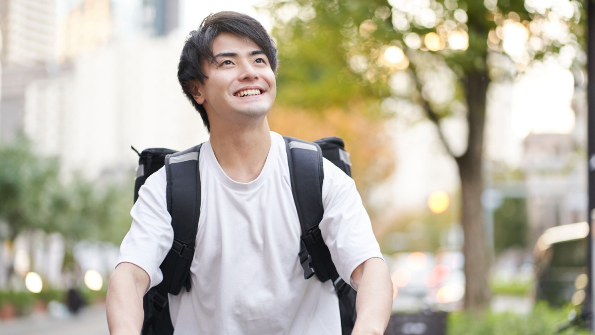 Asian man delivering food outside.