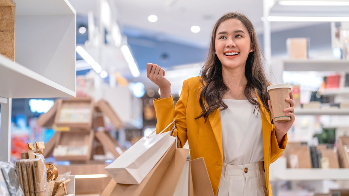 Beautiful asian female woman girl is holding shopping bags and coffee drink, walk and cheerful enjoy smiling while doing shopping in female boutique department store malls happiness window shopping.