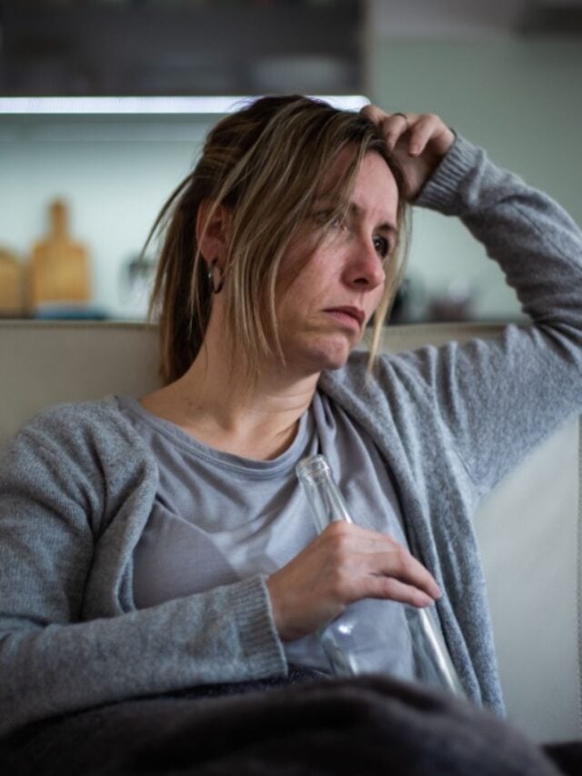 Middle aged woman having a problem, drinking a strong liquor.