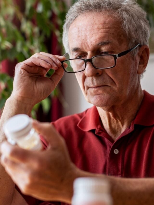 Senior man taking prescription medicine at home.