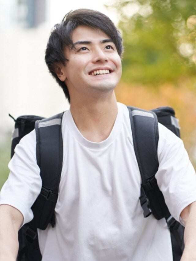 Asian man delivering food outside.