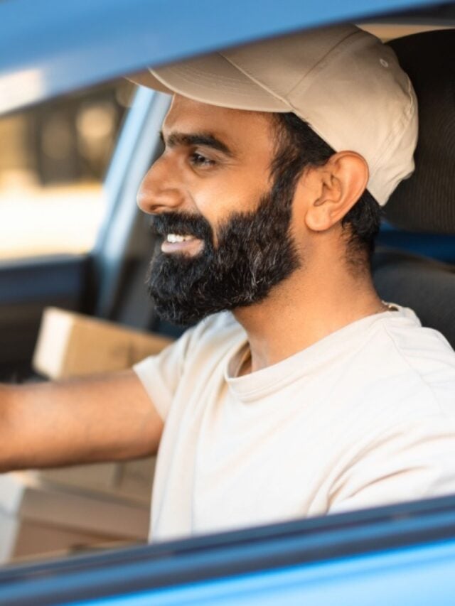 Fast Delivery By Car. Closeup Shot Of Arabic Courier Man Driving Automobile Loaded With Parcels Boxes, Side View.
