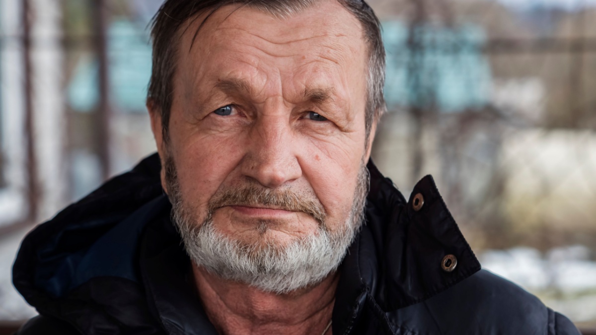 Bearded elderly country man outdoors in winter, real people.