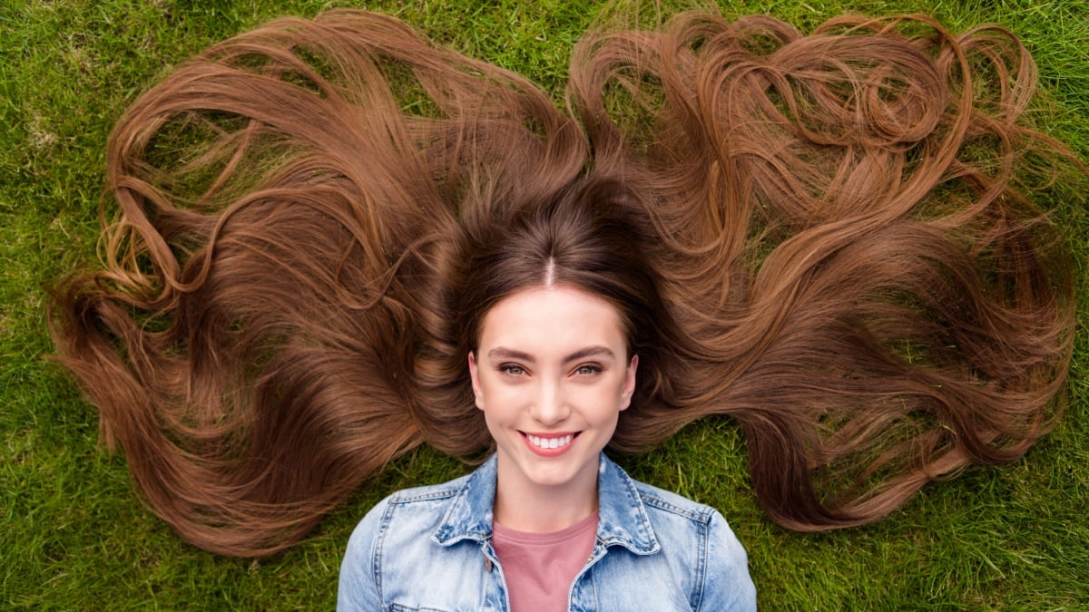 Top above high angle view photo of young cheerful girl happy positive smile lying grass haircare enjoy rest relax outdoors.