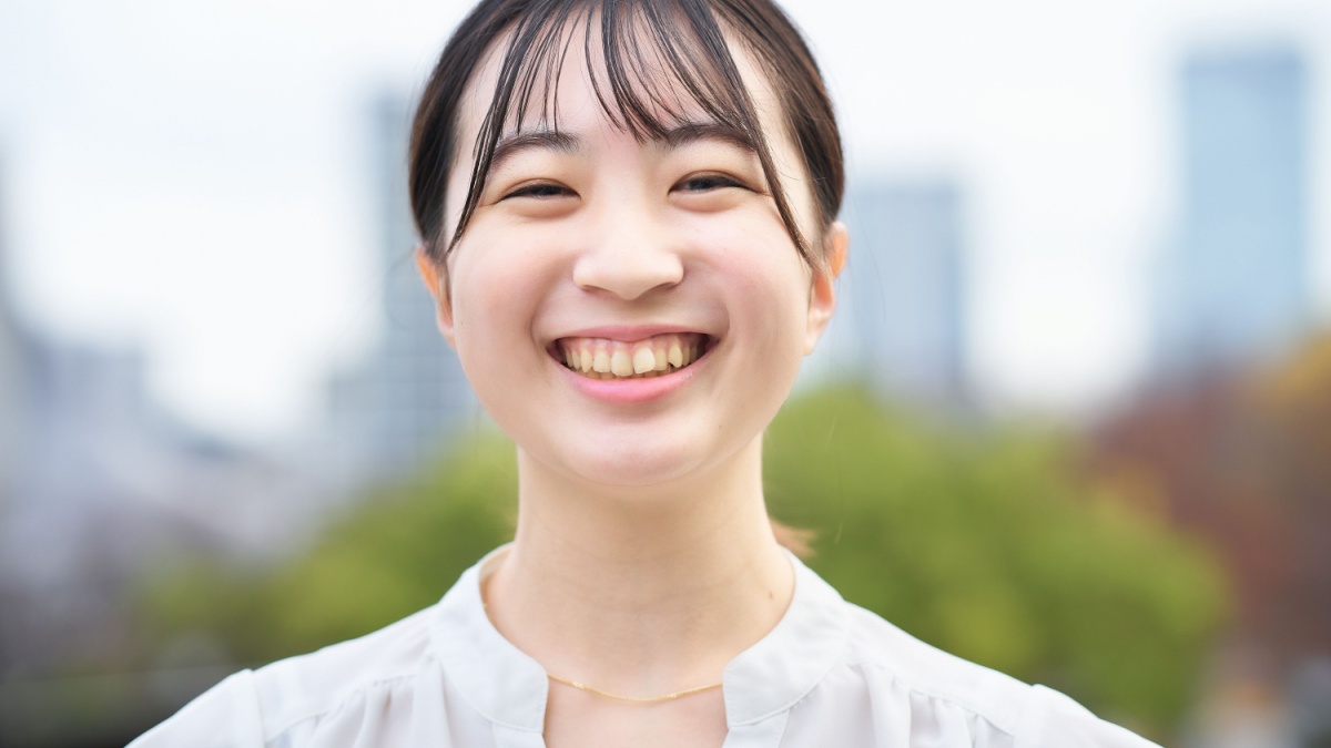 asian young woman smiling outdoors.